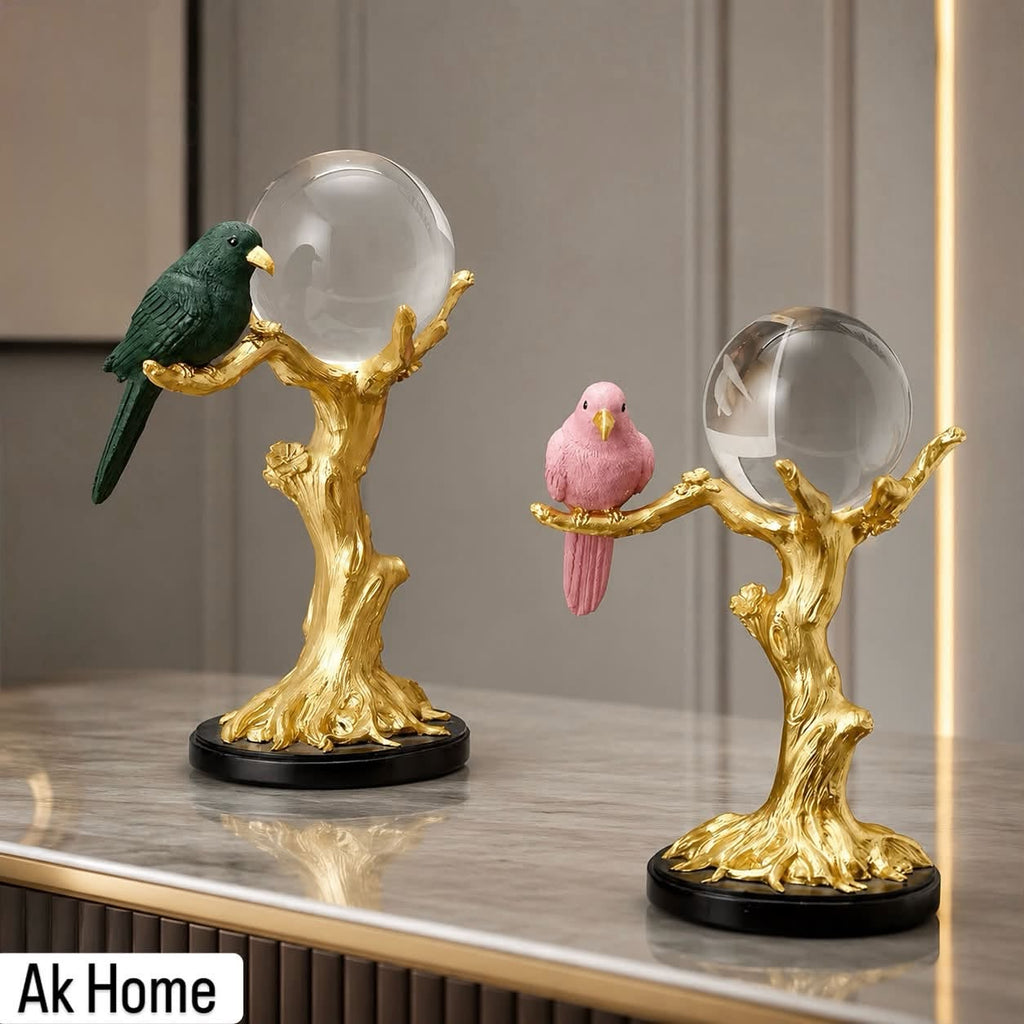 Bird on Golden Tree Crystal Ball Sculpture – emerald green and blush pink bird resin figurines with crystal spheres on marble console