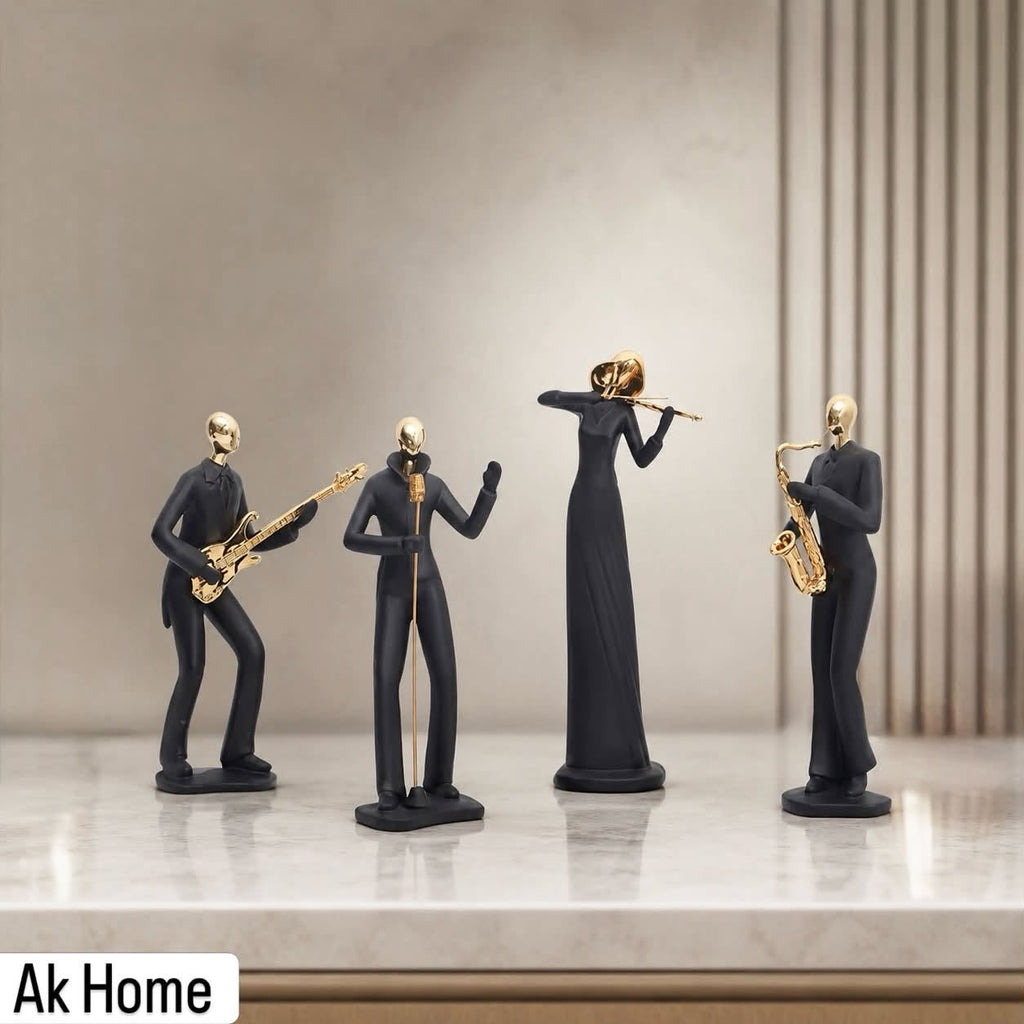 Black & Gold Musician Resin Figurines – set of 4 matte black figures with gold accents playing guitar, singing, violin and saxophone on marble shelf