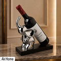 Silver Elephant Wine Bottle Holder – chrome porcelain elephant sculpture on black base cradling a wine bottle