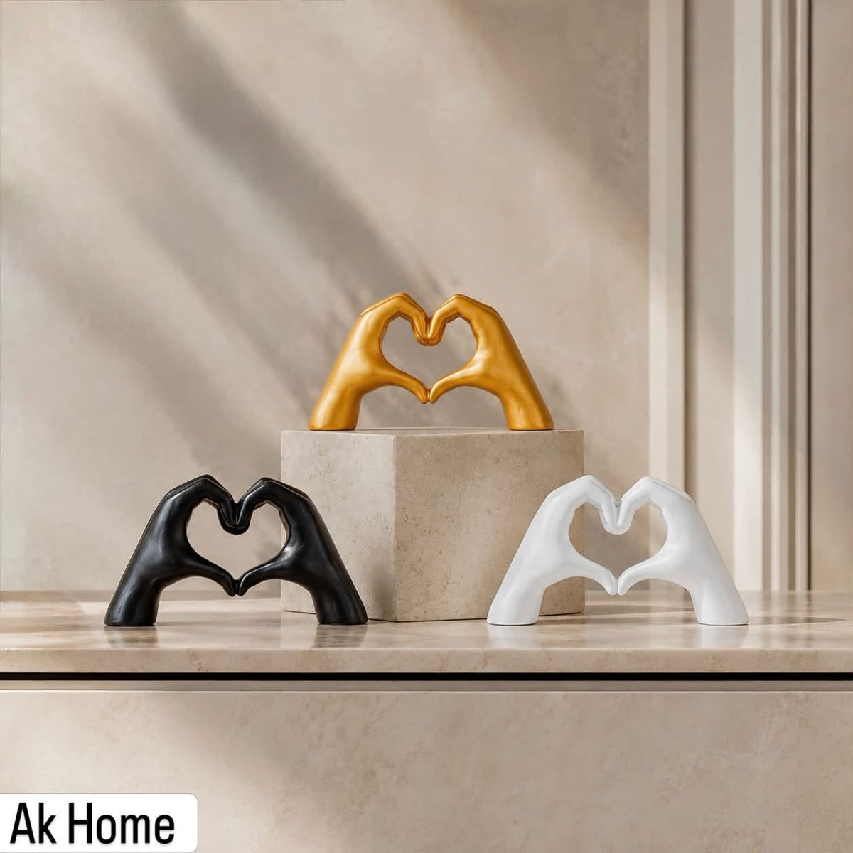 Heart Hands Resin Sculpture – set of three in matte black, matte white, and gold on marble shelf