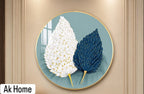 Dual Feather Leaf Round Wall Art – white and navy blue feather leaves on teal background in round gold frame on beige wall