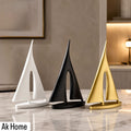 Minimalist Sailboat Sculpture – set of three in matte white, matte black, and brushed gold on marble surface